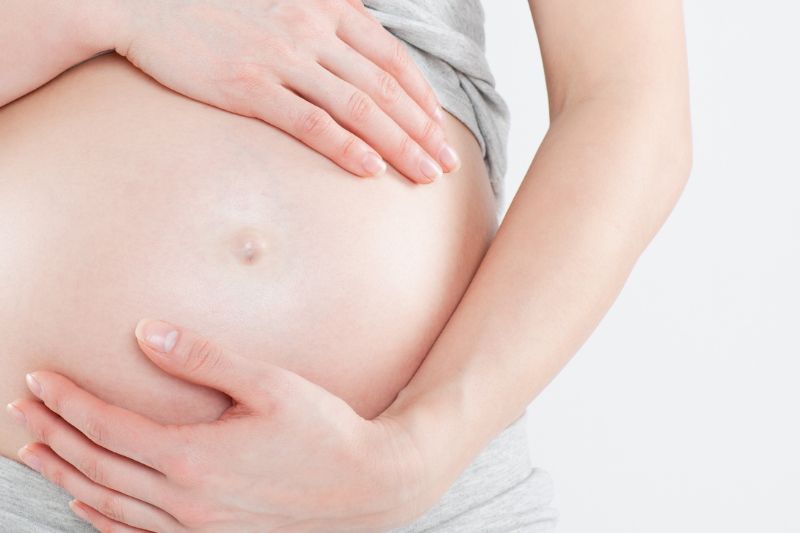 Untitled design (25) Female cradling her pregnancy bump
