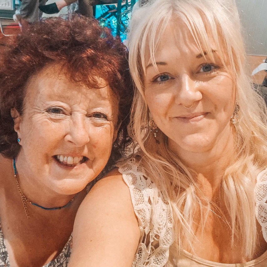 Two females, smiling at the camera. 